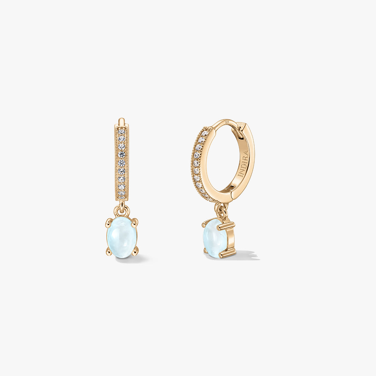 Indira Golden Gem Huggies ezüst fülbevalók ovális holdkő cseppekkel és pavé foglalatos karikákkal, fehér háttéren elölről és oldalról bemutatva.