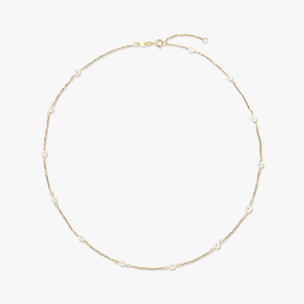 Elegáns 14K sárga arany station nyaklánc, apró, természetes fehér gyöngyökkel a finom láncon egyenletesen elhelyezve, fehér háttéren.