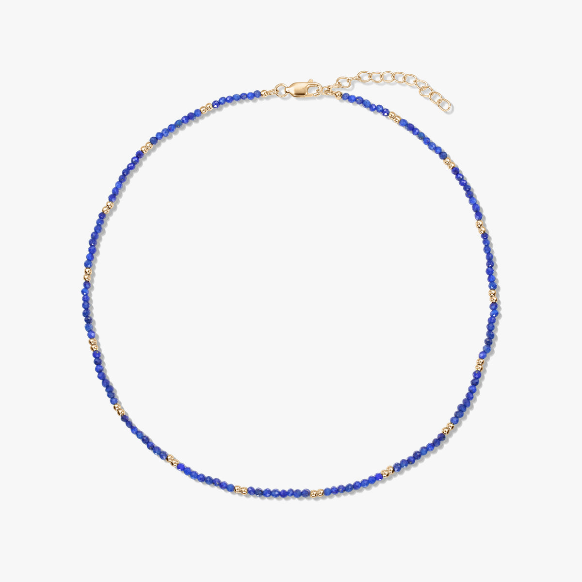 Kecses lápisz lazuli gyöngysor apró, aranyozott sterling ezüst díszítésekkel és állítható delfinkapoccsal, fehér háttéren.